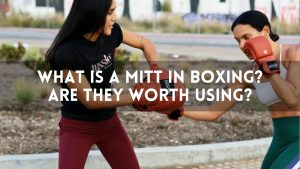Two women training outdoors using boxing mitts, demonstrating a mitt drill. Main keyword: What Is a Mitt in Boxing.